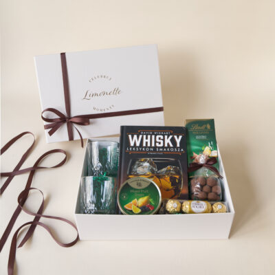 Zestaw Prezentowy Whisky Moments zawiera książkę z ciekawostkami na temat Whisky, dwie szklanki do whisky, landrynki o maku owoców i inne słodycze