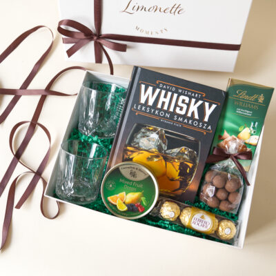 Zestaw Prezentowy Whisky Moments zawiera książkę z ciekawostkami na temat Whisky, dwie szklanki do whisky, landrynki o maku owoców i inne słodycze